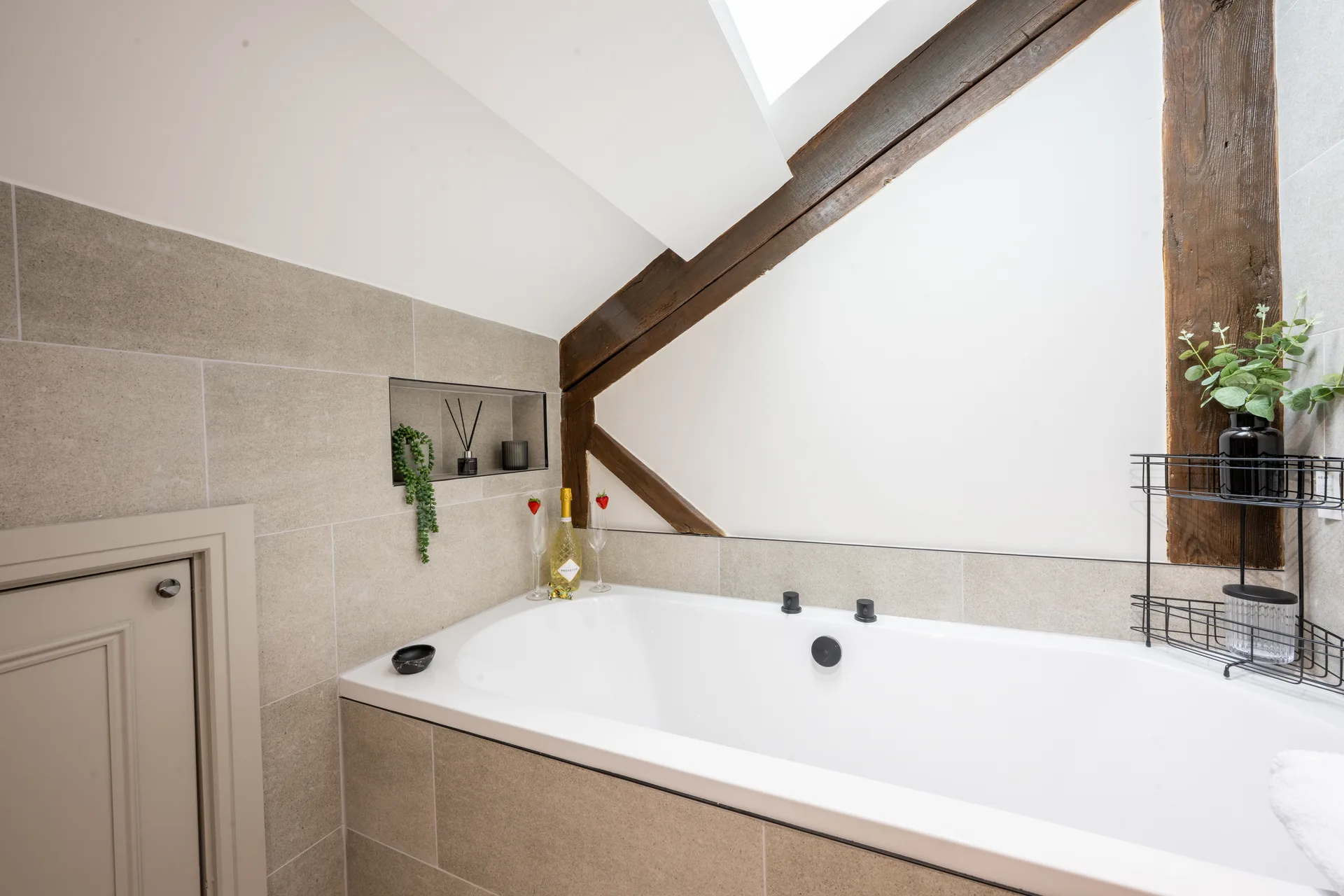 Bathtub beneath wooden ceiling beams in the bathroom