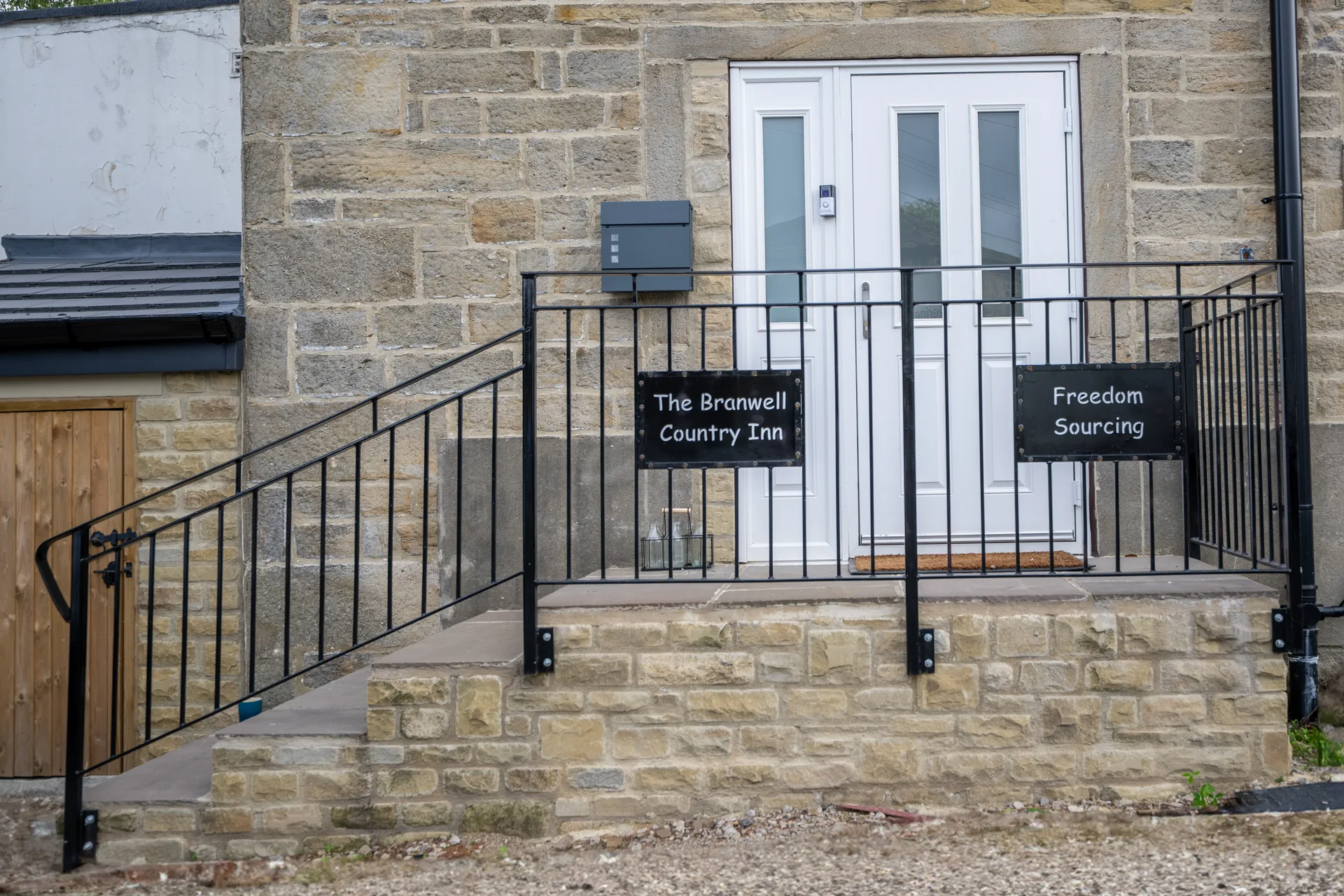Steps and railing leading to the inn's white entrance doors
